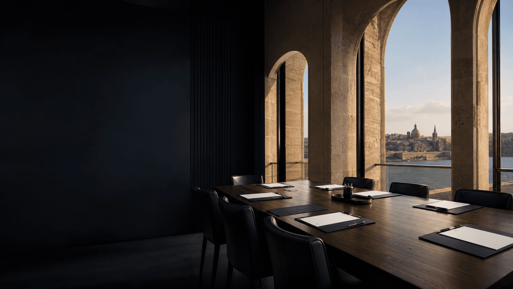 Unoccupied Malta boardroom with blank corporate documents and limestone arches overlooking Valletta