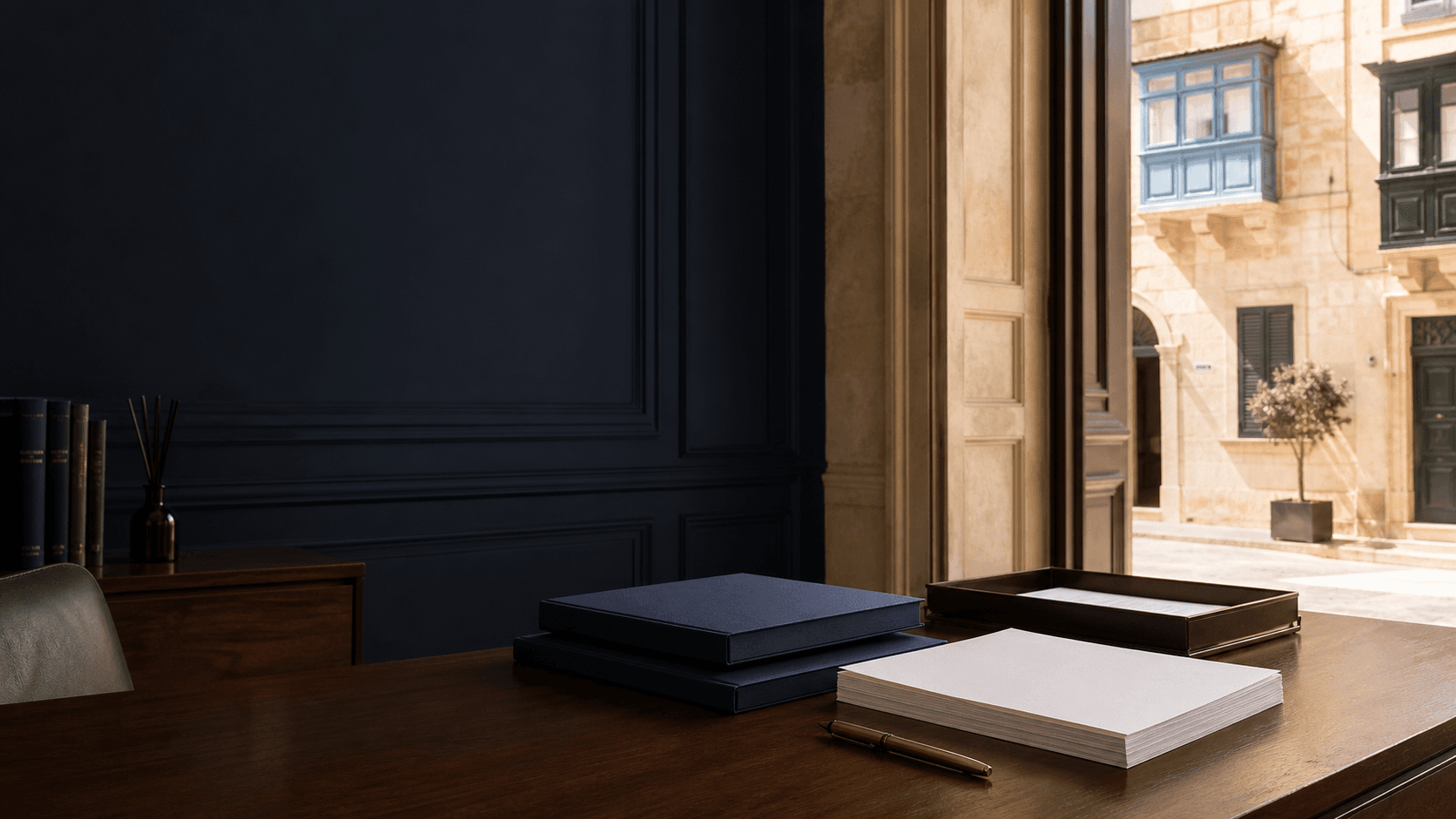 Blank immigration case folios in an unoccupied Malta office opening onto a limestone residential street