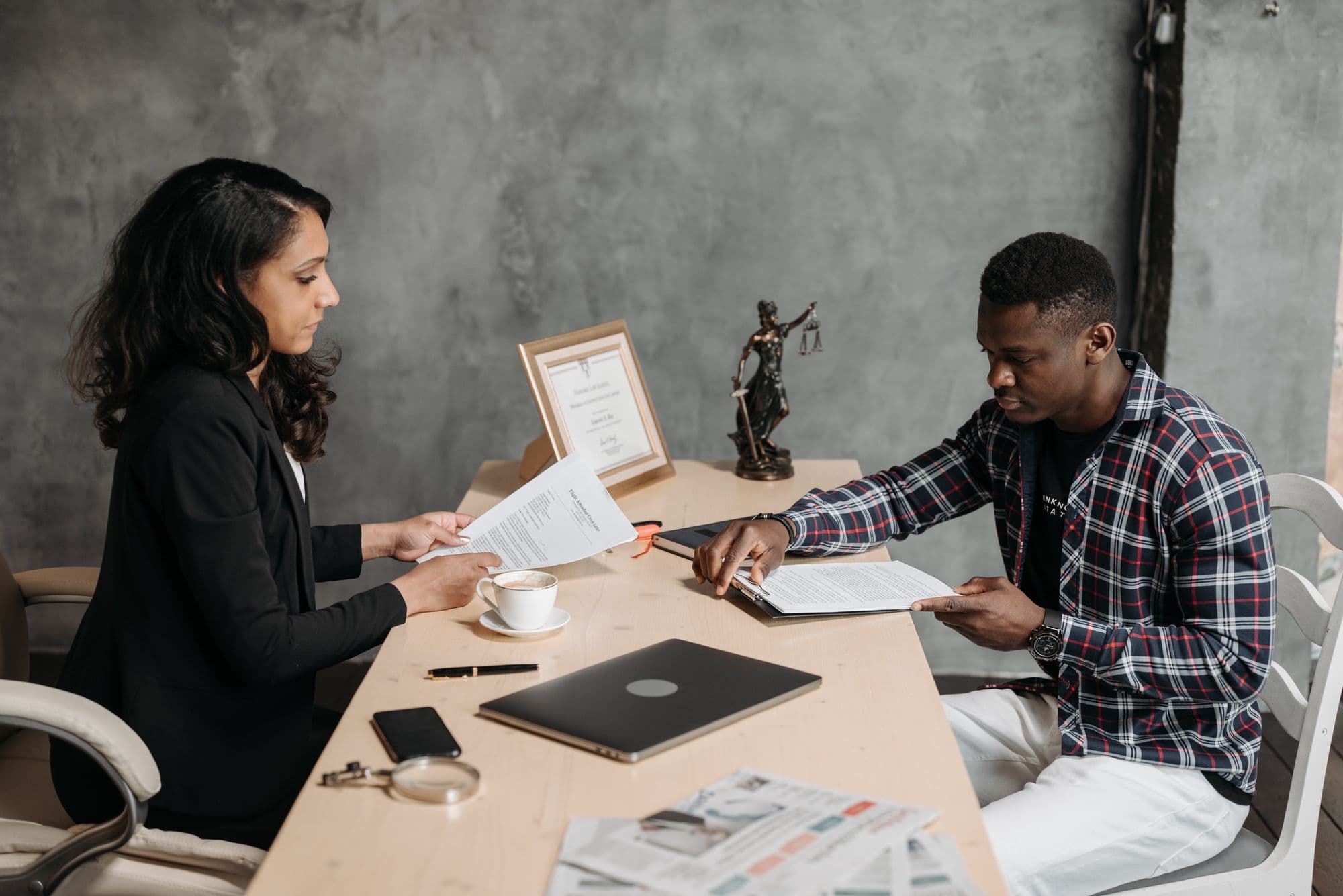Illustrative stock photograph of two people reviewing documents during a legal consultation